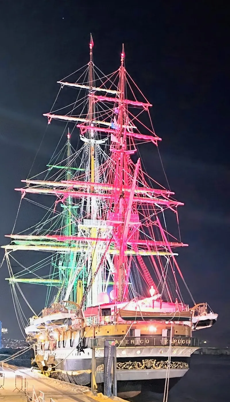 La nave scuola Amerigo Vespucci ormeggiata di notte, con gli alberi e il sartiame illuminati di rosso, bianco e verde