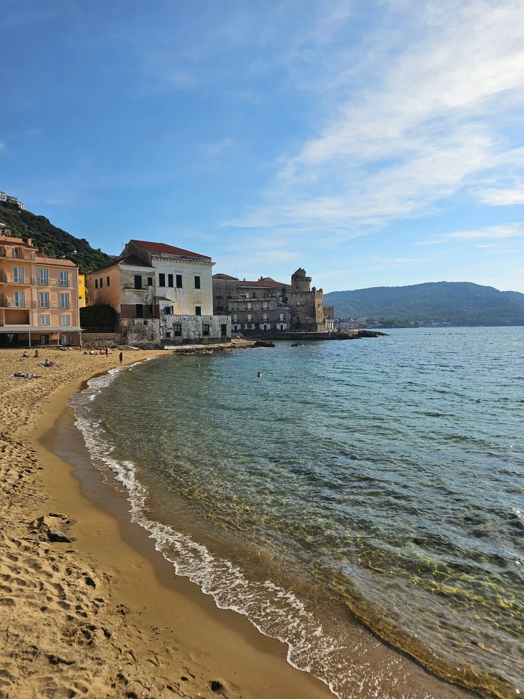 La spiaggia di sabbia dorata di Santa Maria di Castellabate, con le case colorate e la torre sul mare in fondo.