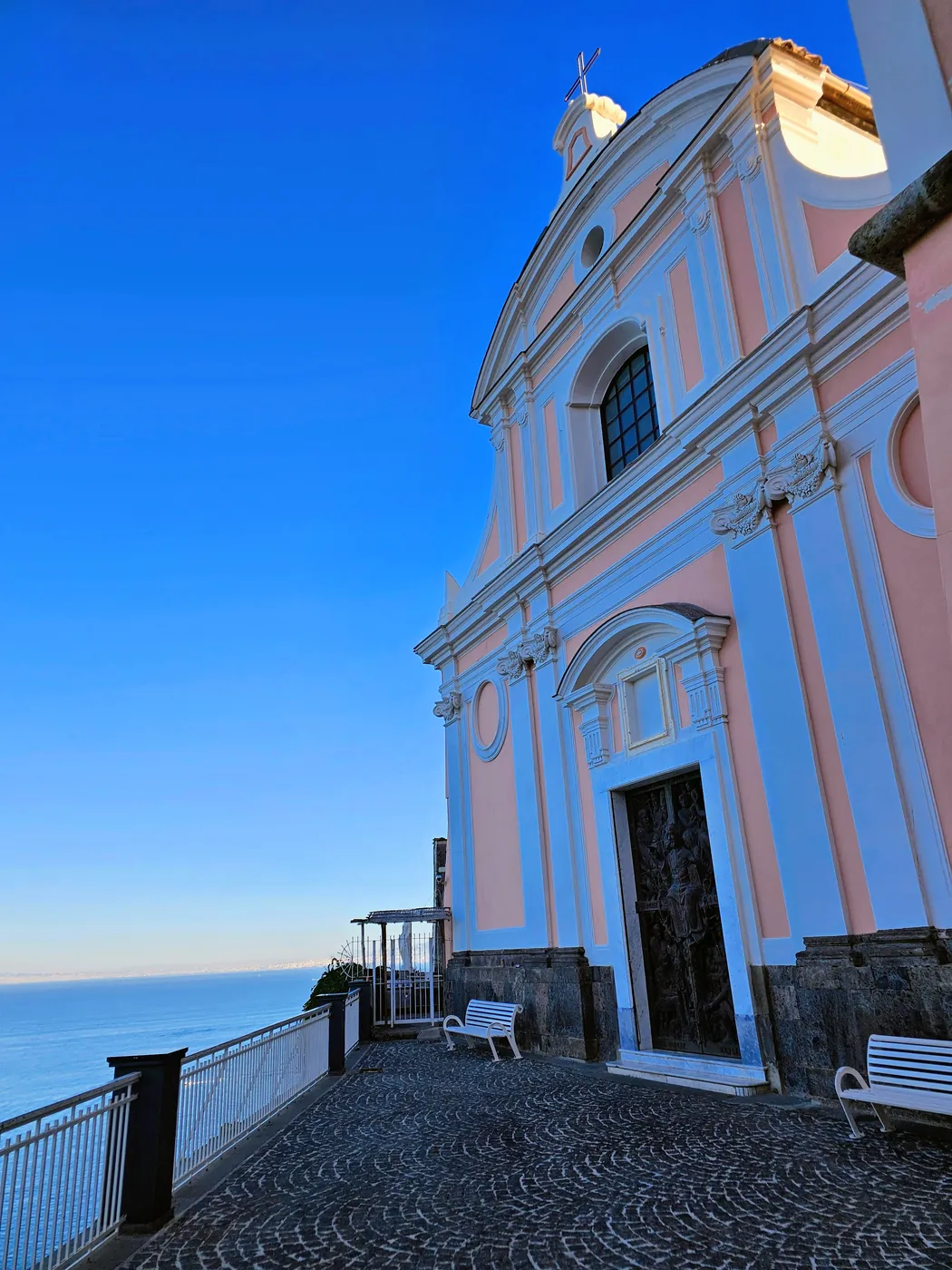 La facciata rosa della chiesa della Santissima Annunziata sul belvedere di Vico Equense, a picco sul mare