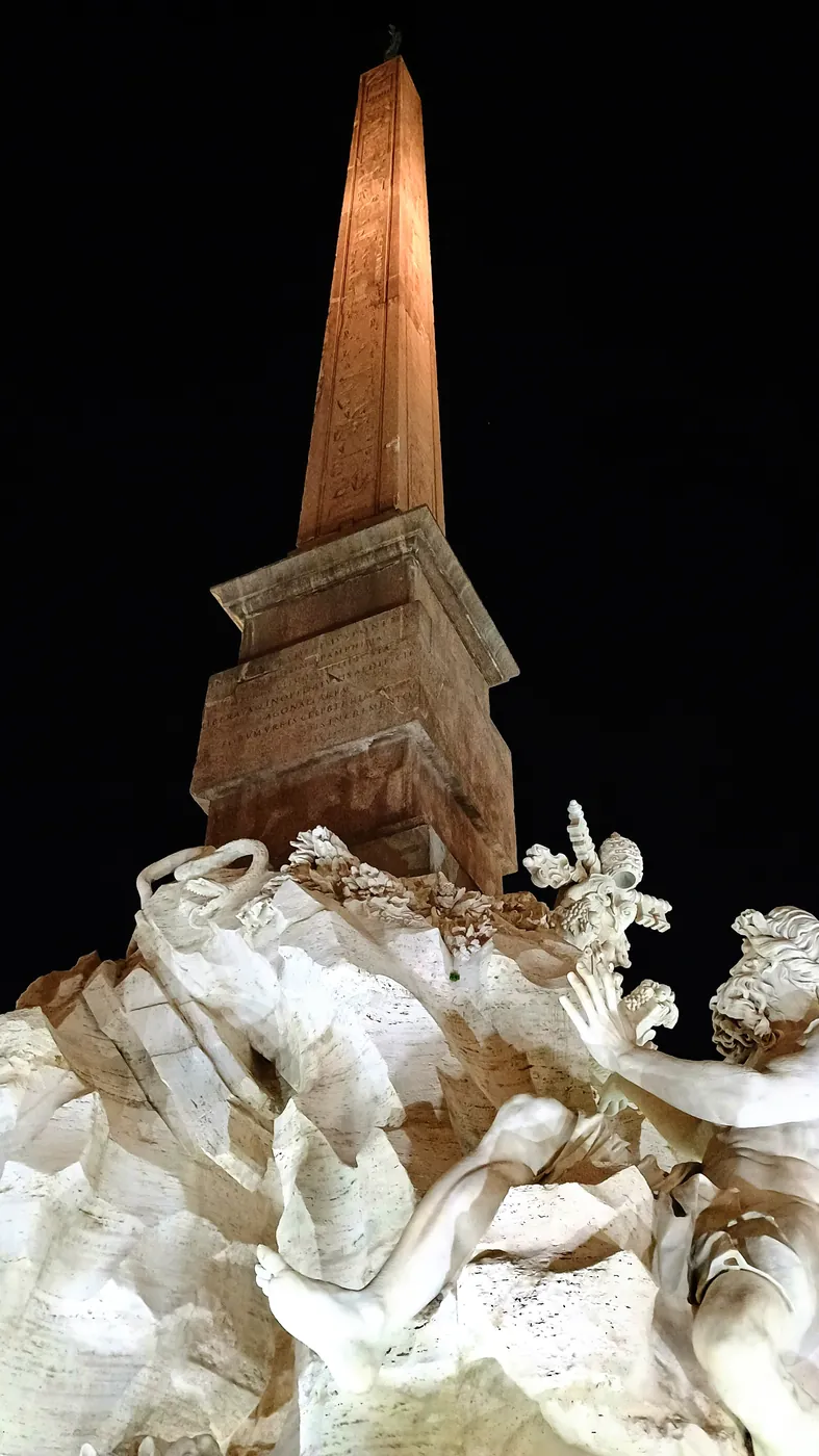 L'obelisco sopra la fontana dei Quattro Fiumi del Bernini, illuminato contro il cielo nero